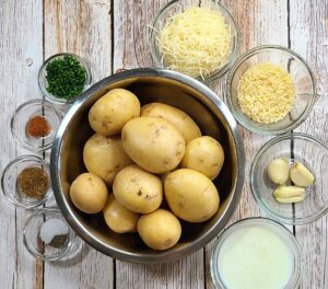 potatoes in a bowl with ingredients in other small glass bowls
