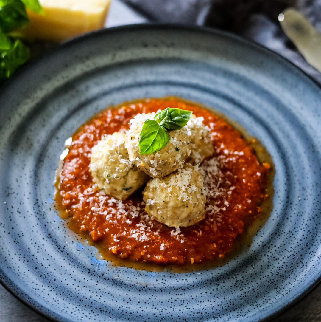 Chicken Meatballs on tomato sauce and a blue plate