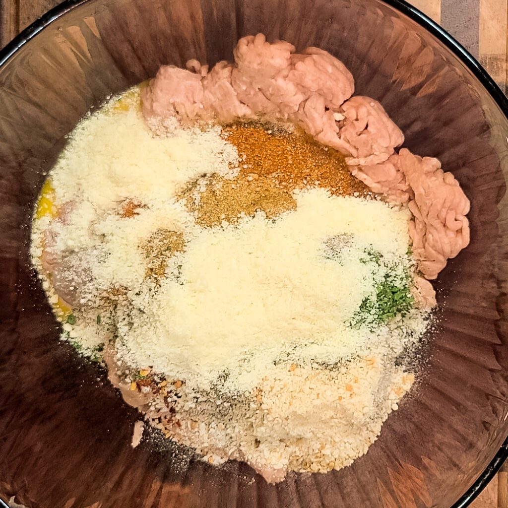 a bowl with chicken meatball ingredients in a glass bowl
